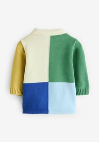 Stickad tröja med ett färgblockeringsdesign i gula, cream, gröna, blå och ljusblå sektioner; korta ärmar och en krage.