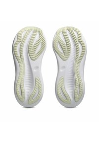 Semelles de chaussures de sport présentant un design en caoutchouc flexible blanc avec des accents verts texturés. Couts courbés pour une adhérence et une stabilité.