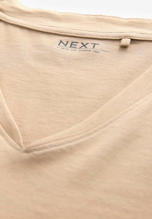 Beige t-paita lyhyillä hihoilla ja v-pääntiellä, valmistettu sileästä puuvillakankaasta. Sisältää painetun etiketin, jossa on brändin nimi "NEXT."