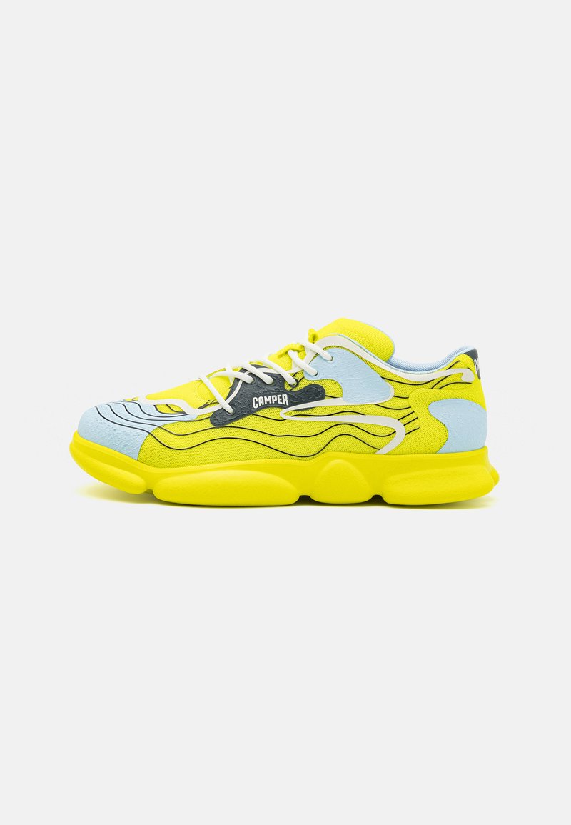 Bright yellow sneaker with blue accents and black wavy lines. Features a cushioned sole, white laces, and a Camper logo on the side.