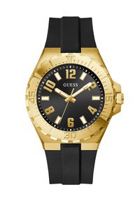 Gullfarget klokke med svart gummirem, dristig svart urskive, store gullfargede time-markører og roterende bezel med gravert minuttskalering.