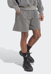 Gray cotton shorts with an elastic waistband and side pockets. Features textured fabric and contrasting vertical stripes along the sides.