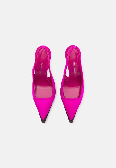 Zapatos de tacón de satén rosa con tiras traseras y punta afilada, con suela negra. Presentan laterales recortados y un acabado brillante en el forro interior.