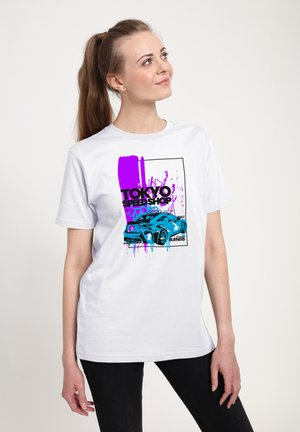 Hvid bomulds T-shirt med et blåt bil grafik og lilla malersplatters samt teksten "TOKYO! SPEED SHOP" i sort. Korte ærmer, afslappet pasform.