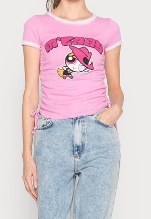 Różowy dopasowany t-shirt z krótkimi rękawami, z nadrukiem postaci z kreskówki. Marszczone detale po bokach oraz koronkowe wykończenie na dekolcie i rękawach.