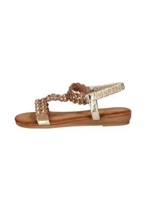 Platte sandaal met bruine zool, gouden metalen enkelbandje en voorste bandjes versierd met ronde bruine kralen en kleine kristallen.