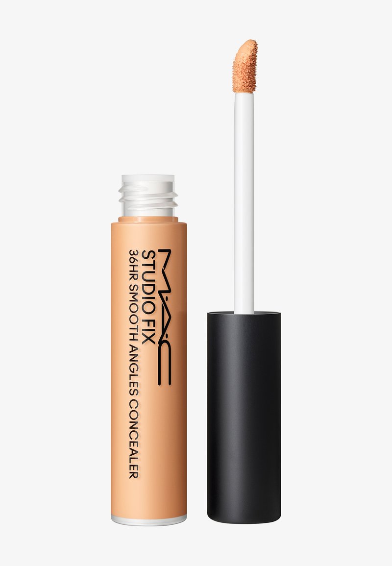 Tube de correcteur MAC Studio Fix 36HR Smooth Angles avec capuchon noir retiré, montrant un applicateur incliné avec un correcteur beige.
