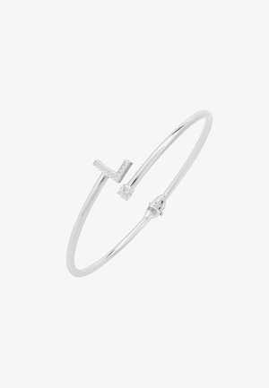 Srebrna bransoletka typu bangle z geometrycznym wzorem w kształcie litery 'L', ozdobiona małymi, przezroczystymi kamieniami, z gładką, polerowaną powierzchnią i zabezpieczającym zapięciem.