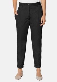 Zwarte enkelhoge broeken met een rechte snit, voorzien van frontzakken, opgerolde broekspijpen en een platte tailleband met een centrale knoopsluiting.