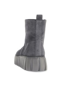 Botas de tobillo de ante gris con una suela gruesa y texturizada de color gris, que cuentan con una tira en la parte trasera y un diseño elegante y minimalista.