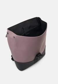 Pink and black bag with a smooth finish, features a tapered design and adjustable strap, and a fabric-lined interior.