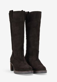 Botas marrones de ante hasta la rodilla con tacón grueso, cremallera lateral, línea superior curva y costuras blancas a lo largo de la suela.