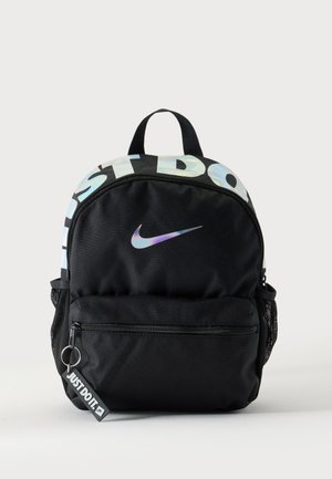 Czarny plecak Nike z holograficznym logo, przednia kieszeń na zamek z brelokiem "JUST DO IT." oraz siateczkowymi kieszeniami bocznymi na białym tle.