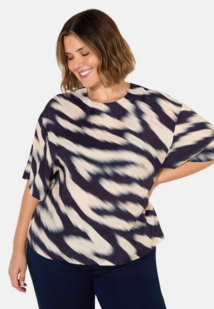 Loose-fitting top in lightweight fabric. Features a cream and navy striped pattern, rounded neckline, and short sleeves.