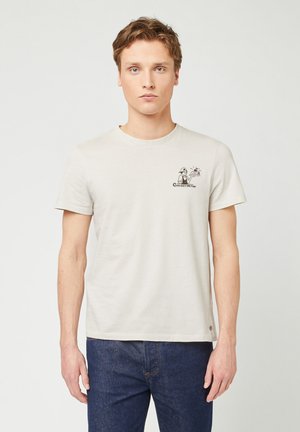 Helles beiges Baumwoll-T-Shirt mit kurzen Ärmeln und rundem Ausschnitt, versehen mit einem Cartoon-Print auf der linken Brust und dem Text "Cherry on Top".
