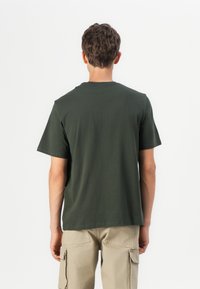 Dark green cotton t-shirt with short sleeves and a crew neckline, featuring a plain design and a relaxed fit. Back view shown.