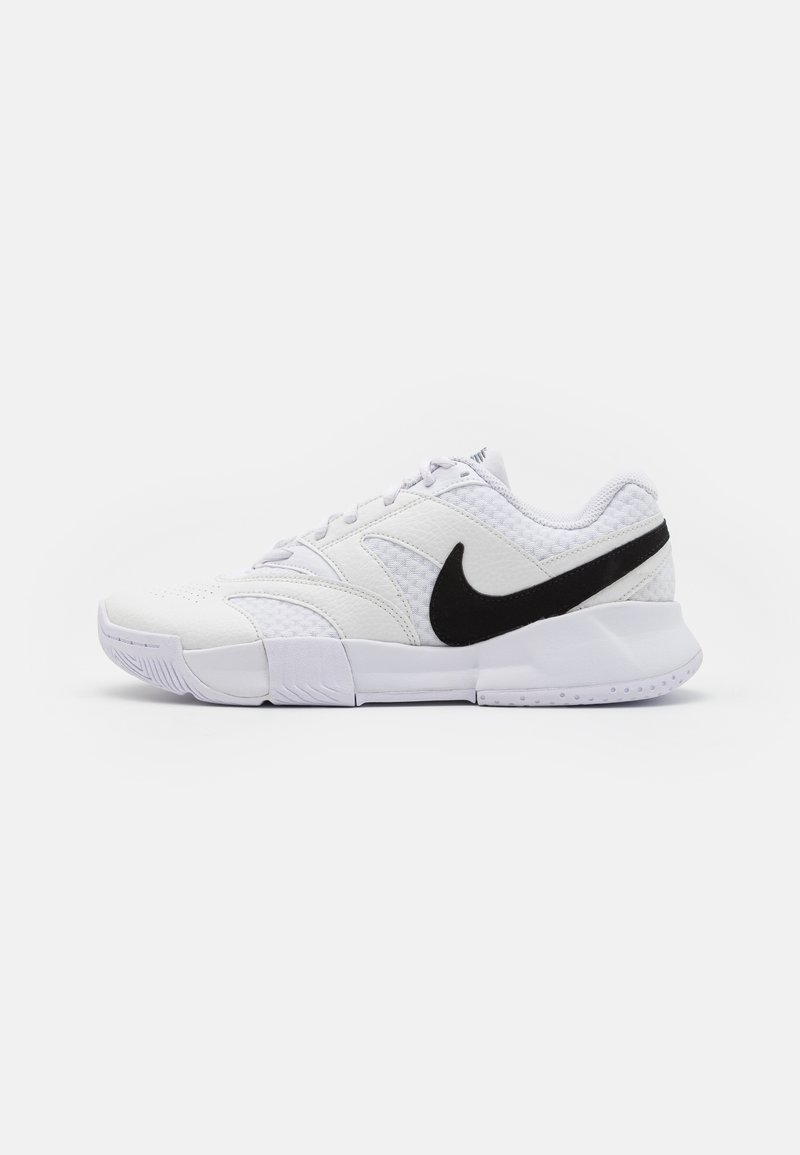Bijela atletska cipela s teksturiranim kožnim gornjim dijelom, crnim swoosh logom i podstavljenim izrezom. Sadrži gumeni potplat za prianjanje.