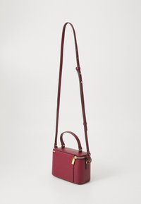 Small rectangular dark red leather crossbody bag with gold zipper and adjustable shoulder strap against plain background.