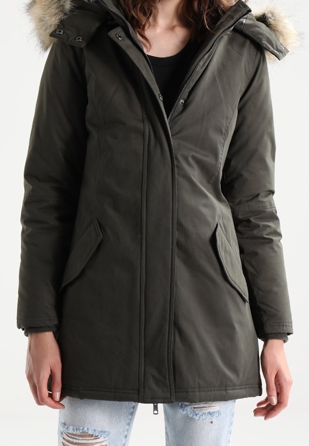 Parka vert foncé avec une capuche bordée de fourrure, fermeture éclair, poches latérales et poignets côtelés. Le matériau semble épais et résistant aux intempéries.