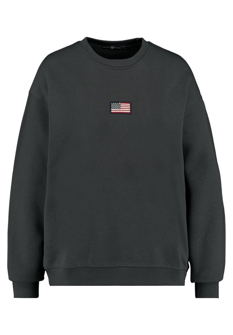 Svart crewneck sweatshirt med långa ärmar, som har en liten broderad amerikansk flagga centrerad på bröstet.
