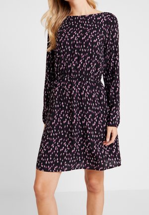 Schwarzes Kleid mit langen Ärmeln, elastischer Taille, durchgehend mit einem pink-weißen abstrakten Muster. Hergestellt aus leichtem, fließendem Stoff.