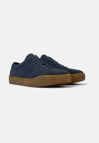 Navy suede sneakers with rounded toe, lace-up front, and a textured, light brown rubber sole. Simple design, no visible embellishments.