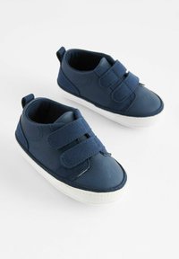 Baskets bleu marine avec deux bandes Velcro, fabriquées en matériau texturé. Semelles en caoutchouc blanc avec un motif de semelle, design minimaliste.