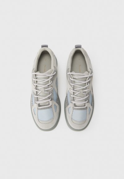 Baskets grises avec des panneaux en maille bleu clair, des accents en daim et des lacets gris. Comprend une semelle texturée et des détails réfléchissants.