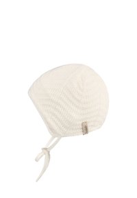 White knitted hat with a textured pattern, pointed shape, and ties at the chin. Features a small brand tag on the side.
