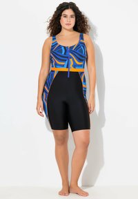 Multikleurige eendelige zwempak met een blauw en oranje abstract patroon, zwarte shorts en een ritsluiting aan de voorkant. Gladde textuur.