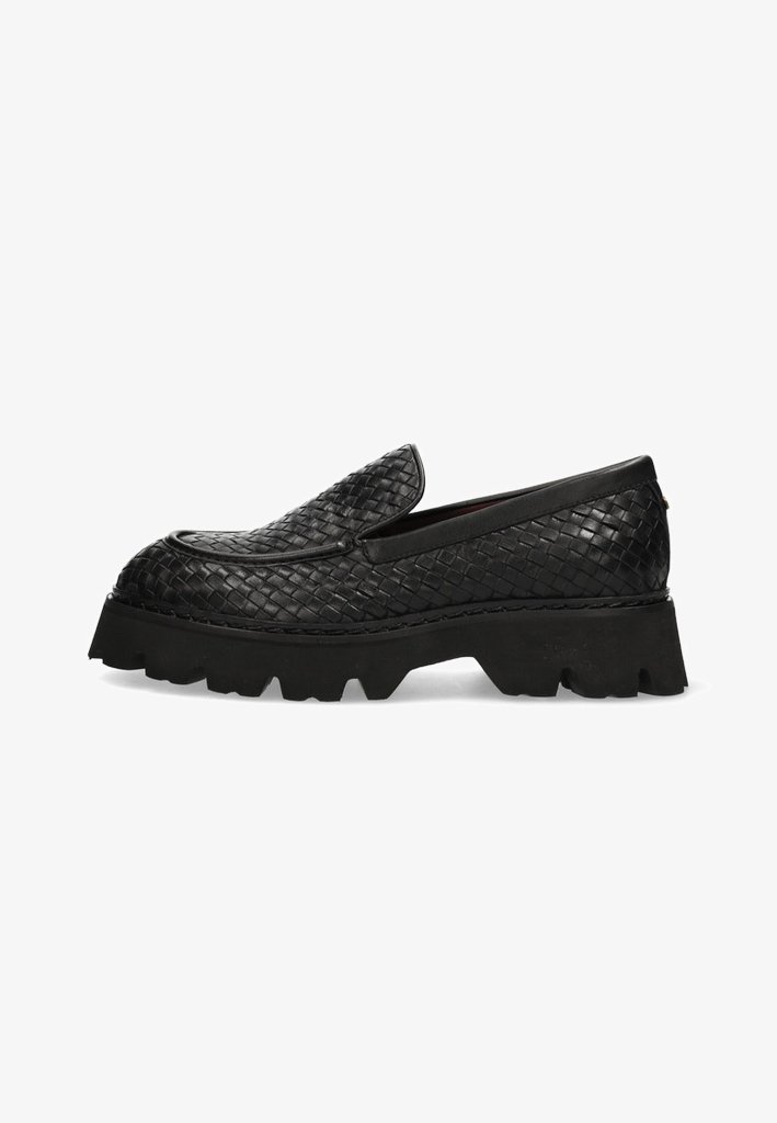 Black woven slip-on shoes with a chunky rubber sole. Features a smooth leather upper and a textured, raised pattern.