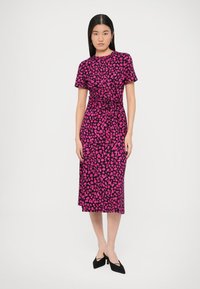 Sukienka w kwiatowy wzór w jasnoróżowym i czarnym kolorze, z krótkimi rękawami, dopasowaną talią i długością midi. Materiał o teksturze i gładkim wykończeniu.