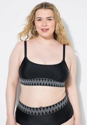 Top da nuoto nero con spalline regolabili, caratterizzato da un cinturino testurizzato a zigzag bianco. Il bottom a vita alta coordinato presenta un design simile.