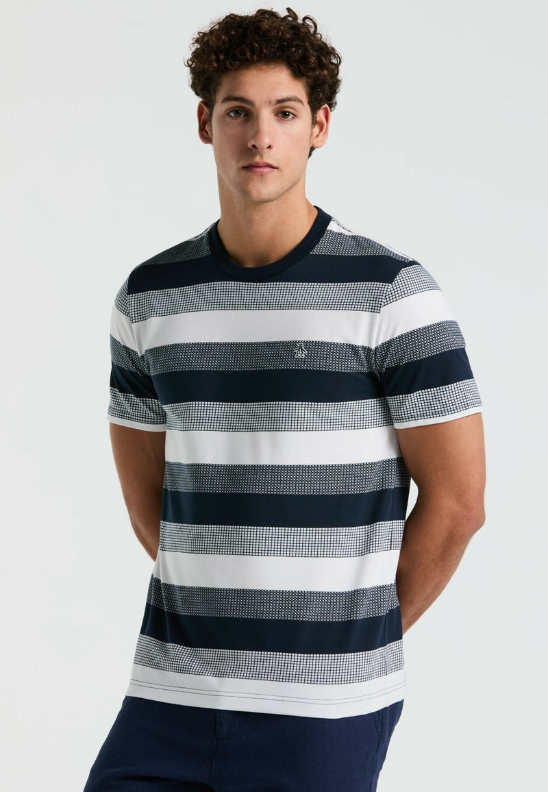 T-shirt rayé en navy et blanc avec des lignes horizontales présentant des motifs variés. Col rond classique et manches courtes. Fabriqué en coton.