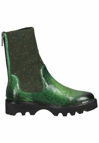 Bottine verte avec devant en cuir à texture crocodile, tige en tissu tricoté à pois multicolores, semelle à crampons noire et fermeture éclair à l'arrière.