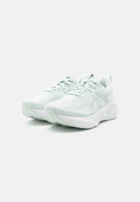 Baskets de sport vert clair avec une tige en maille, bout arrondi et semelle épaisse blanche avec un motif texturé pour l'adhérence.