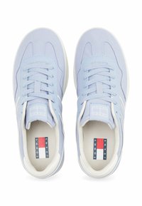 Sneakers azzurri chiari con suole e lacci bianchi, dotati di un logo sulla linguetta e di una grafica sui plantari.
