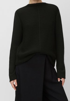 Pull en maille vert foncé avec un col rond, des manches longues et une finition texturée. Il présente une couture centrale et un ourlet arrière légèrement plus long.