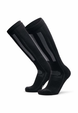 Een paar zwarte compressiekousen tot aan de knie met grijze verticale strepen en verstevigde tenen en hiel.