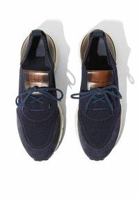 Tamno plavi tenisice od mrežastog materijala i nubuka, s smeškim kožnim detaljem na jeziku, okruglim vezicama i debelim belim đonom.