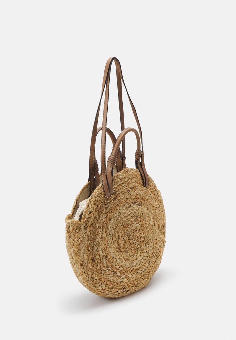 Sac cabas rond en paille tissée avec deux poignées courtes et deux longues en cuir marron, présenté sur fond blanc.