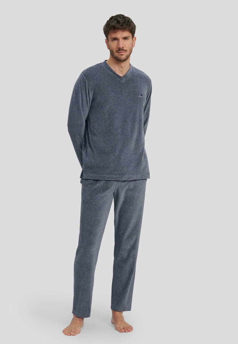 Conjunto de pijama de cuello en V de color azul marino hecho de tela suave; incluye mangas largas y pantalones con un ajuste relajado y sutiles detalles de costura.