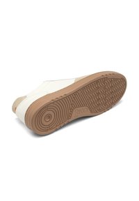 Sneaker, mille tekstureeritud valgest nahast pealispind ja tan suède aksendid. Omab kummist väljalaset, millel on mustriga kulumine, et tagada haardevõime.
