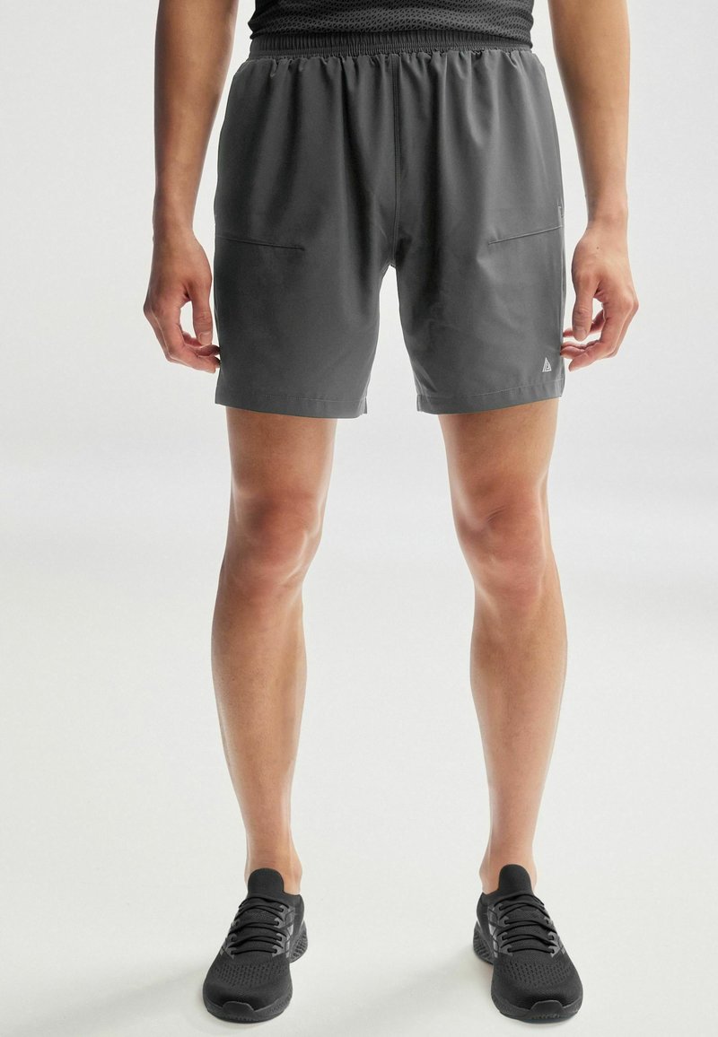 Grå atletiske shorts med snor i taljen, der har to sidelommer, og et glat, letvægtsstof.