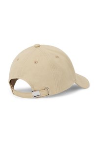 Gorra beige hecha de tela texturizada con visera curva, correa ajustable en la parte trasera y una etiqueta de acento metálico.