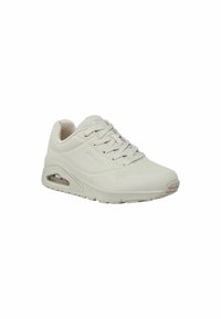 Zapatillas Skechers de color beige claro con una parte superior texturizada y transpirable, diseño de cordones y una suela con almohadilla de aire. Las perforaciones añaden detalle.