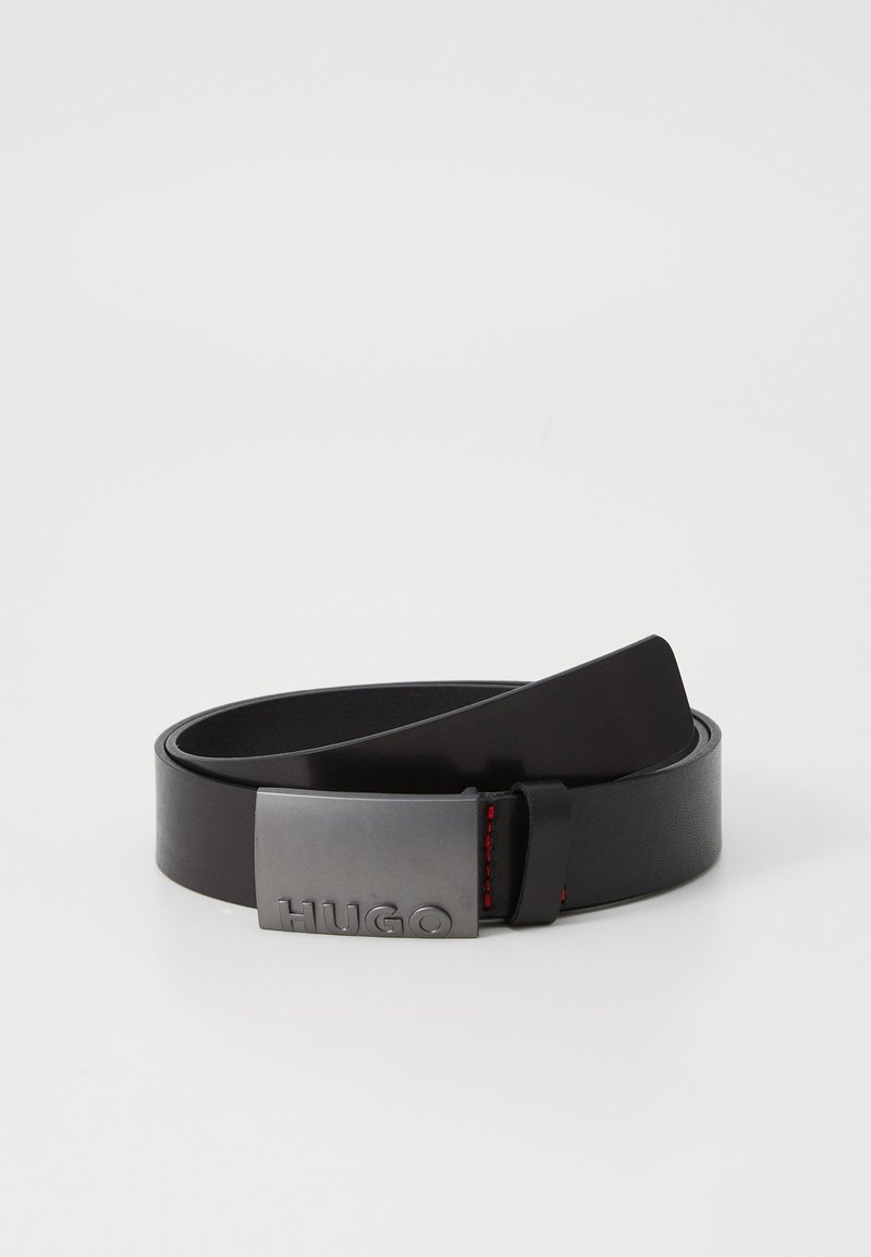 Sort lærbelte med en rektangulær sølvspenne som har det gravert merkevarenavnet "HUGO" og røde sømdetaljer.