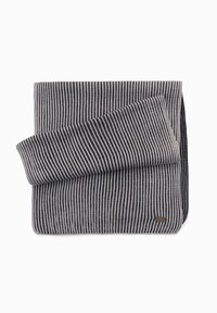 Coperta grigia e nera a righe con una texture morbida, caratterizzata da un bordo piegato e un piccolo etichetta in tessuto sul lato.