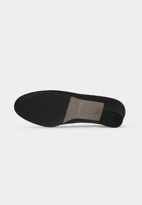 Semelle de chaussure plate noire avec bout et talon texturés, étiquette indiquant la marque "Gabor", taille 42½, et texte "Made in Spain".