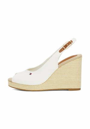 White canvas wedge sandals with a peep toe, jute-wrapped platform, and a brown leather buckle strap. Features a small logo on the front.